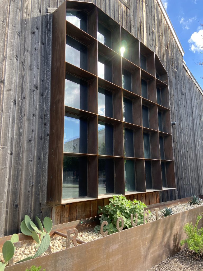 Location: Lone Star Court, Austin, Texas, Wood Highlights: Exterior siding in knotted wood paired with corten window frame