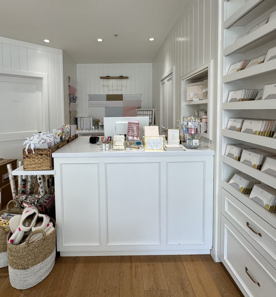 Location: Sugar Paper, Larkspur, California, Wood Highlights: Classic painted wood trim design at store checkout counter with painted wood wall treatment provides a bespoke experience reinforcing brand values