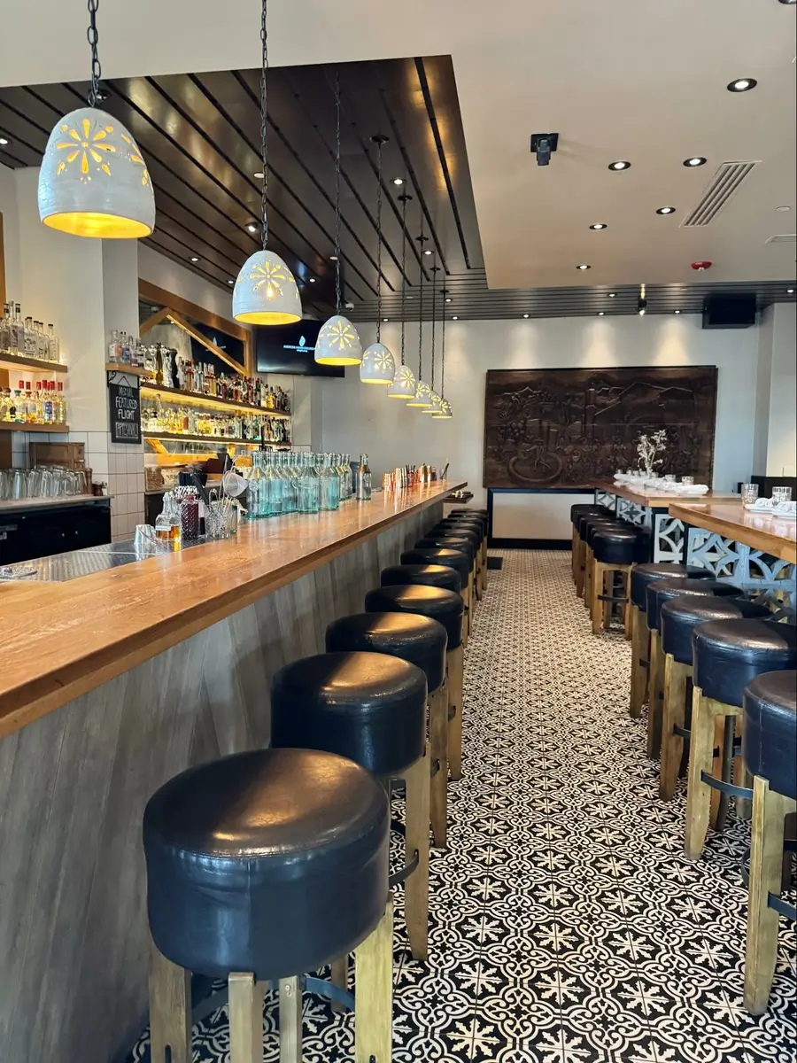 Location: Flores, Corte Madera, California, Wood Highlights: Wood at face of bar, ceiling area, bar back and wood countertop with wood edge