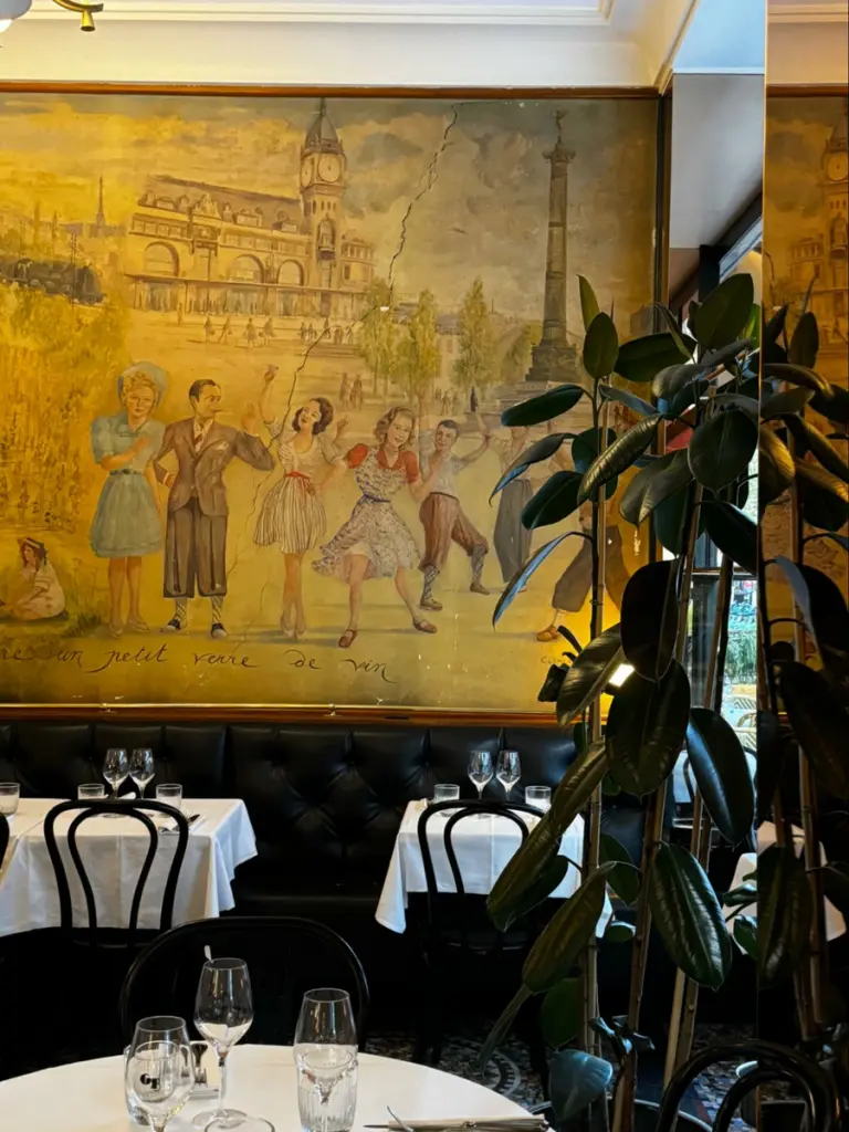 Location: Cafe, Paris, France, Wood Highlights: Painted architectural trim moulding design at ceiling above banquette seating combined with natural wood trim framing mural