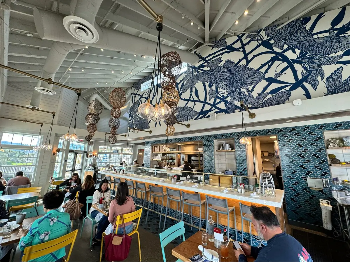Location: Hog Island Oyster Company, Larkspur Landing, California, Wood Highlights: Warm wood trim at face of bar, wood at soffit below Tom Killion mural