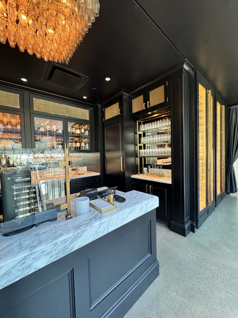 Photo credit: Metaphor Edge, Location: Restoration Hardware Wine Bar, Corte Madera, California, Wood Highlights: Black painted crown moulding, baseboards, island trim, wall trim, columns