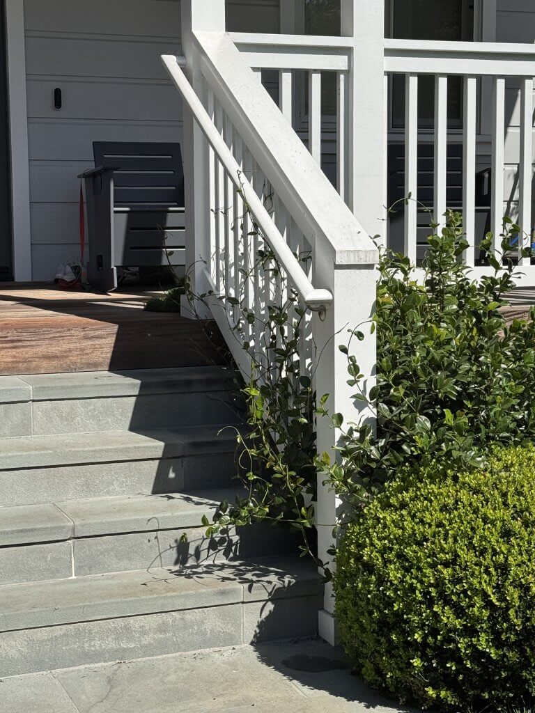 Wood Highlights: handrails at this remodeled farmhouse sit conveniently below flat edge guardrails next to trimmed posts, and S4S pickets, easing the entry and exit, important for aging in place design and demonstrating how handrails that are easy to grip can be installed next to guardrails
