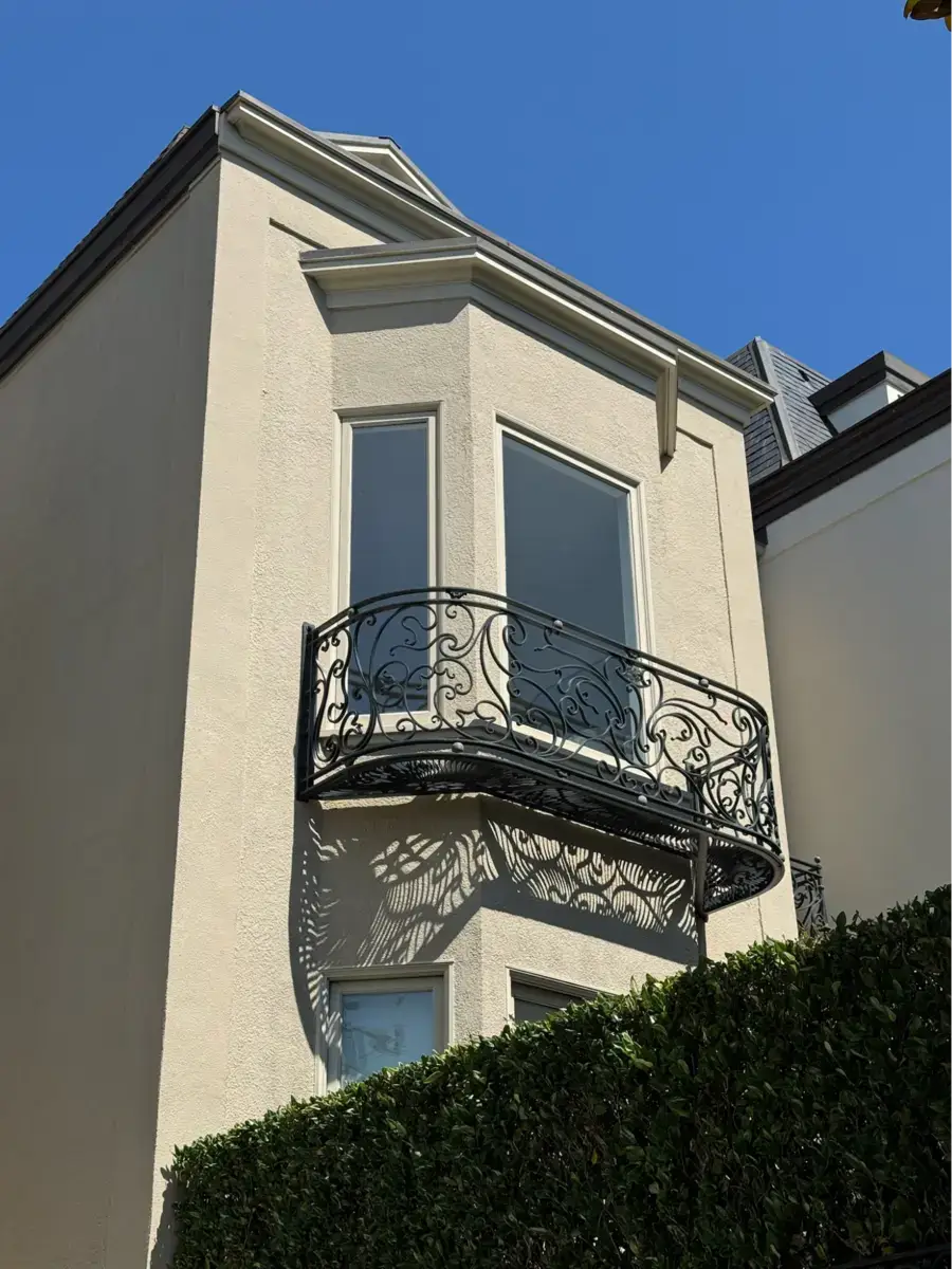 Location: San Francisco, California, Wood Highlights: Stucco mouldings provide crisp window surrounds against textured stucco walls behind an iron balcony. These exterior trim profiles protect edges while reinforcing vertical proportion.