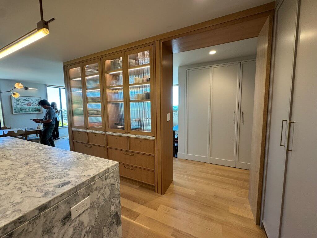 Wood Highlights: Desert colors on painted custom contemporary millwork include a ventilated area below the extended radius edge bench seat for an elegant contemporary take on a vestibule or mud room design that accommodates shoes, jackets, and items needing quick storage to serve this family every day. Architecture by Blue Truck Studio. Interiors by Studio Muir.