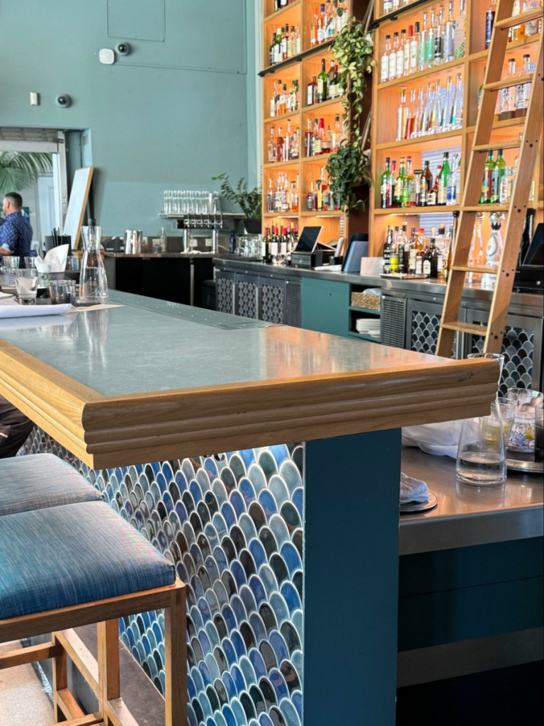 Location: La Mar, San Francisco, California, Wood Highlights: Sculpted oak edge detail above blue fish-scale tile at Embarcadero waterfront bar.