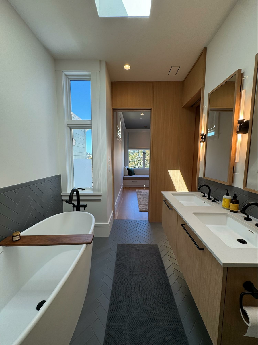 Location: Eureka Valley Home, San Francisco, California, Wood Highlights: The primary bath offers a clean palette of crisp white traditional window and door casings mixed with contemporary trim details in a contrasting wood to create a strong sense of place for a soothing sensory experience in this area of retreat and rejuvenation at the home.