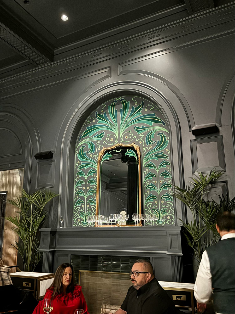 Location: Bourbon Steak, San Francisco, California, Wood Highlights: The use of repetition in the built up trim breaks down the scale of the wall, incorporated with the lighting, sound system and the fireplace focal point, flourishing with a bright green inset mural.
